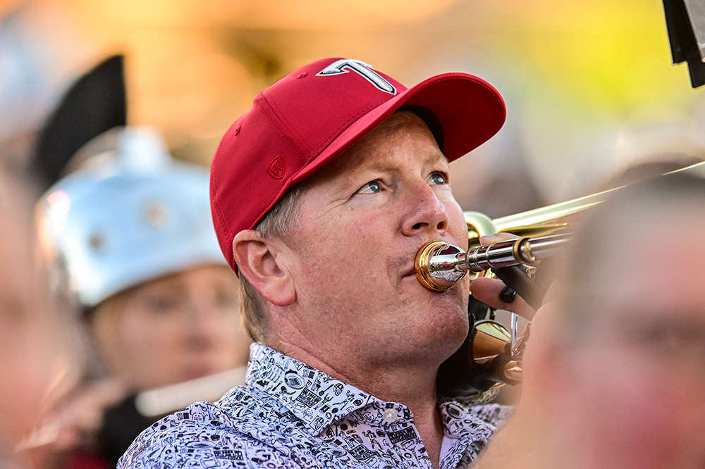 An alum plays his instrument