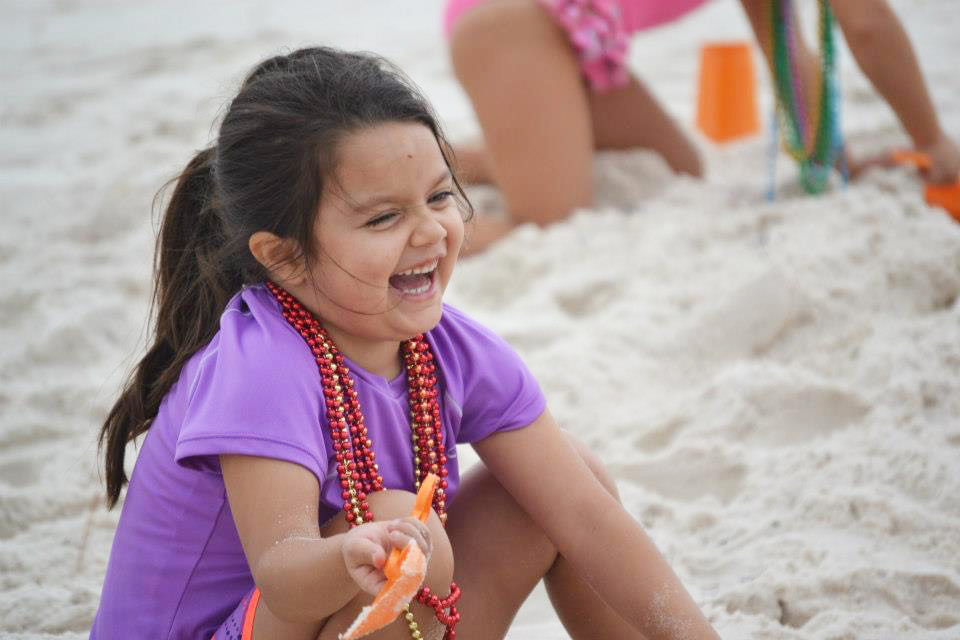 Ansley as a young child playing in the sand at the beach