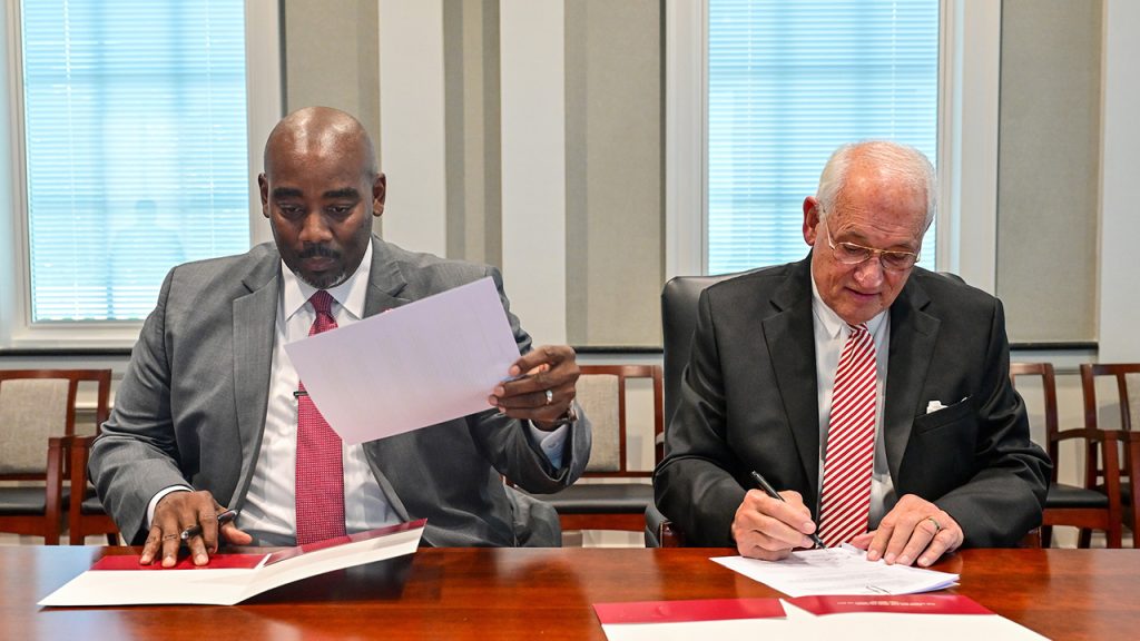 Ozark City Schools Superintendent Reeivice L. Girtman is shown with Troy Chancellor Jack Hawkins, Jr. signing the partnership agreement.