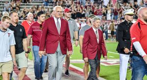 Dr. Hawkins joins other Marines in the Walk of Heroes at this year's Military Appreciation game at TROY's Veterans Memorial Stadium.