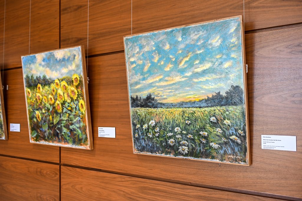 Smothers' paintings of a sunflower field and a farm landscape.