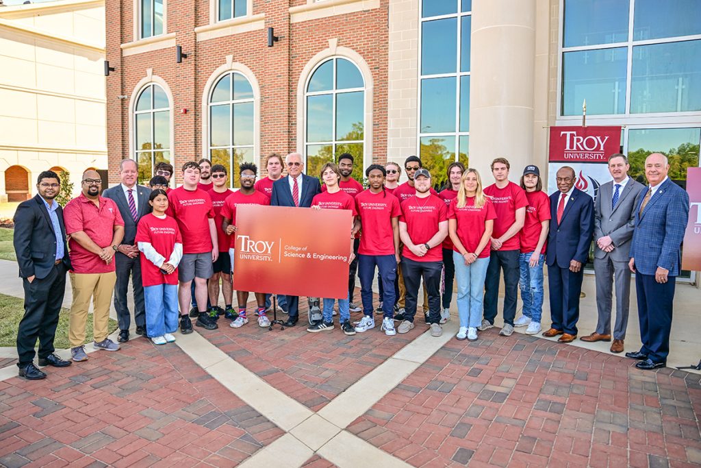 Students pose with TROY officials and guests following the press conference