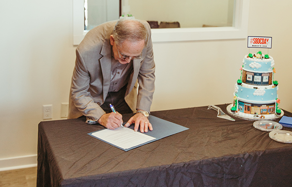 Elba Mayor Tom Maddox signs a proclamation designating March 19 as SBDC Day in Elba at the Elba Chamber of Commerce.