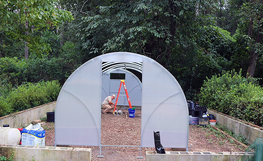 Arboretum volunteers work on building the new greenhouse.