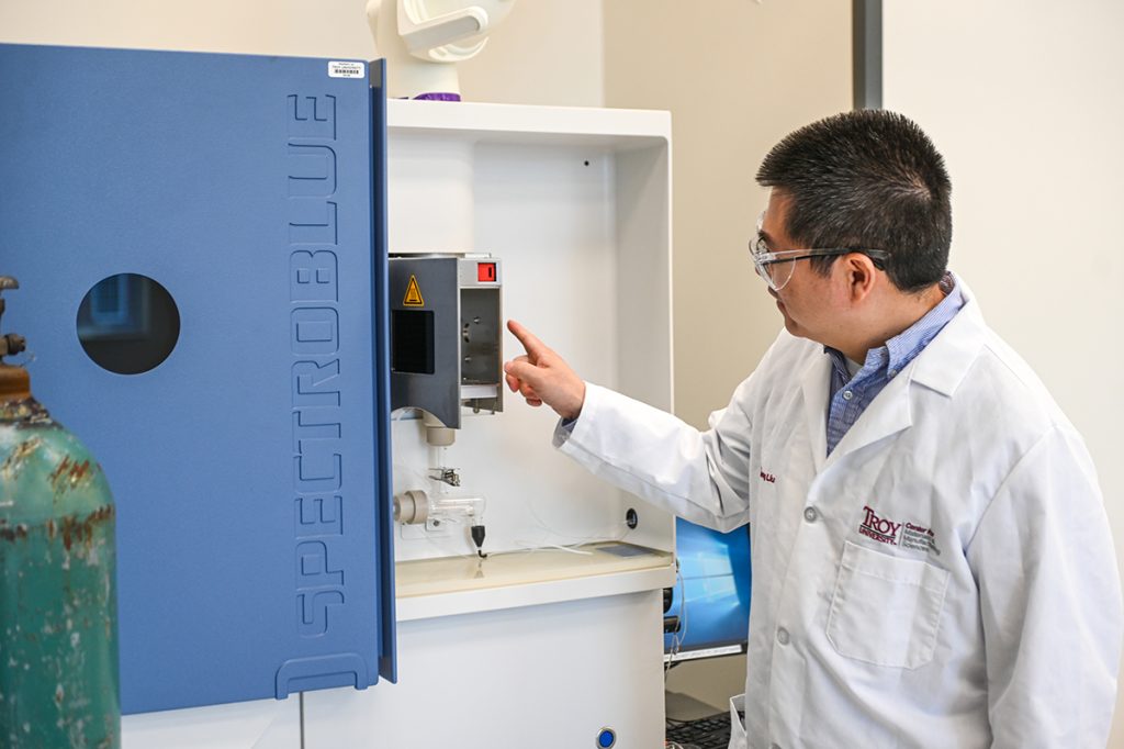 Dr. Liu in his research lab using equipment.