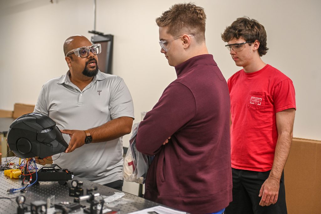 Dr. Raj Vinnakota shows students a project during Engineering Day.