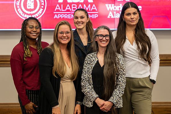 a photo in of five people at a conference