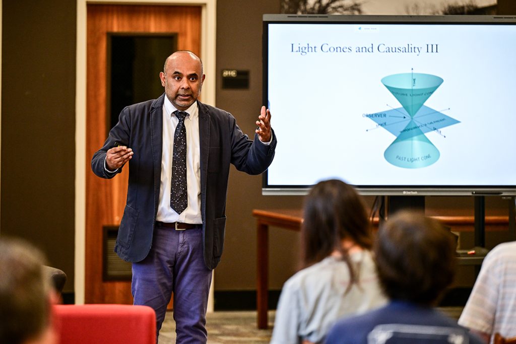 Dr. Govind Menon giving a lecture about black holes and light cones in the Troy University Library