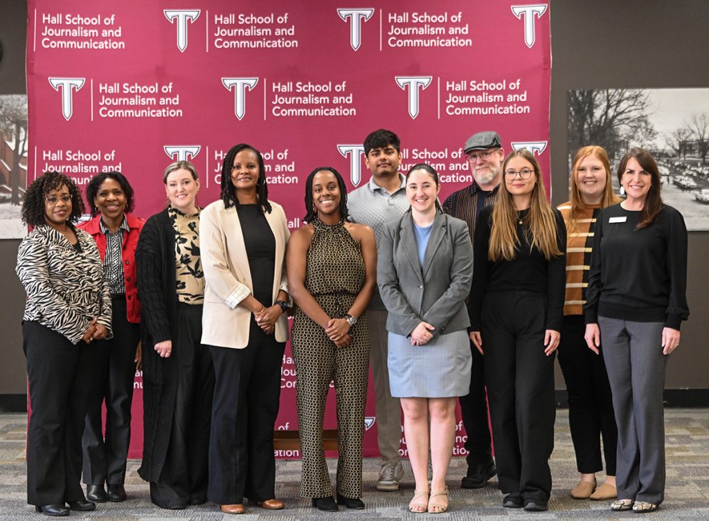 Journalism faculty pose for a photo in the Troy University Library with the speech tournament winners.