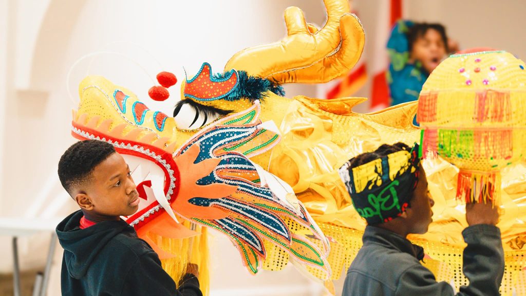 Two elementary school students look at a Chinese dragon during last year's International Arts Center Trojan Junior Warrior program.