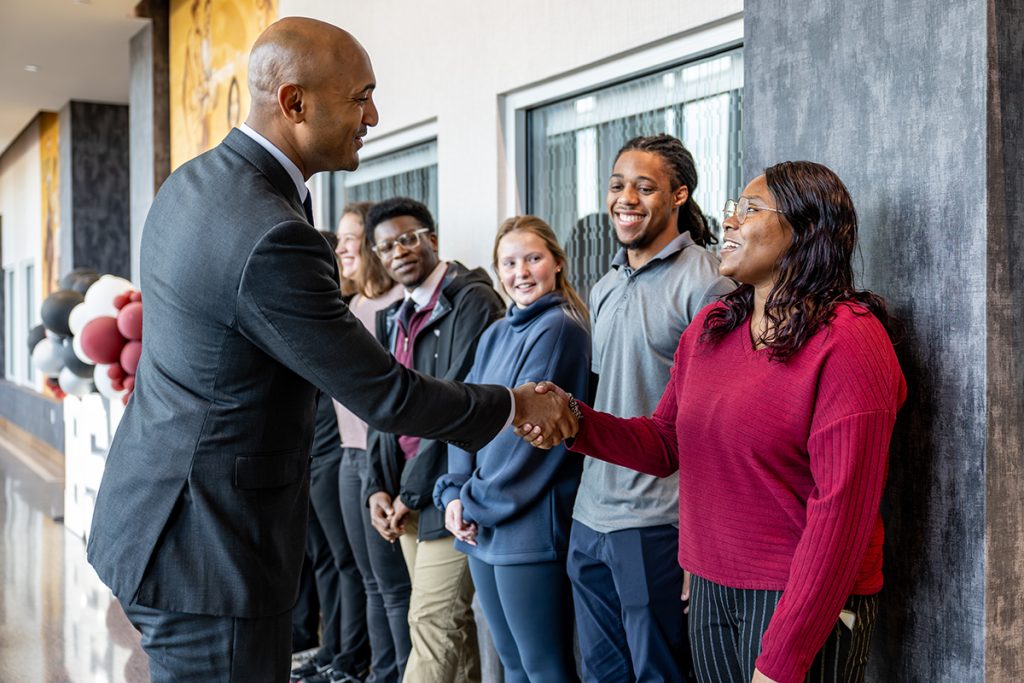 Alabama Congressman Shomari Figures shakes hands with a nursing student in Jones Hall.