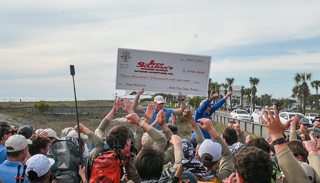 Griffin Brock and Jeep Sullivan hold up the check to a crowd, announcing the total of $200,000.