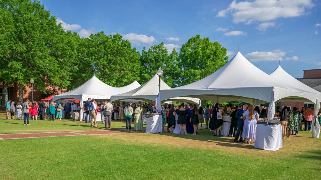 Students and guests gather under tents on the quad for a reception following the 2026 Honors Convocation.