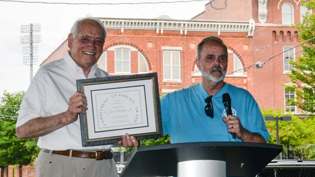 Dr. Jack Hawkins, Jr., TROY Chancellor, receives the Commitment to Service Award from Michael Coleman, chair of the Sunrise Rotary Club's annual Shrimp Boil fundraising event.