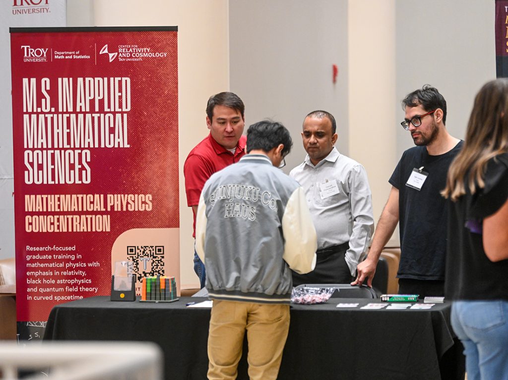 TROY math faculty talk to a student at TROY's applied mathematics grad program table at MathFest.