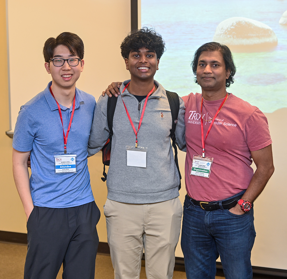 Dr. Suman Kumar, TROY professor and general chair of ACMSE 2026, with two attendees