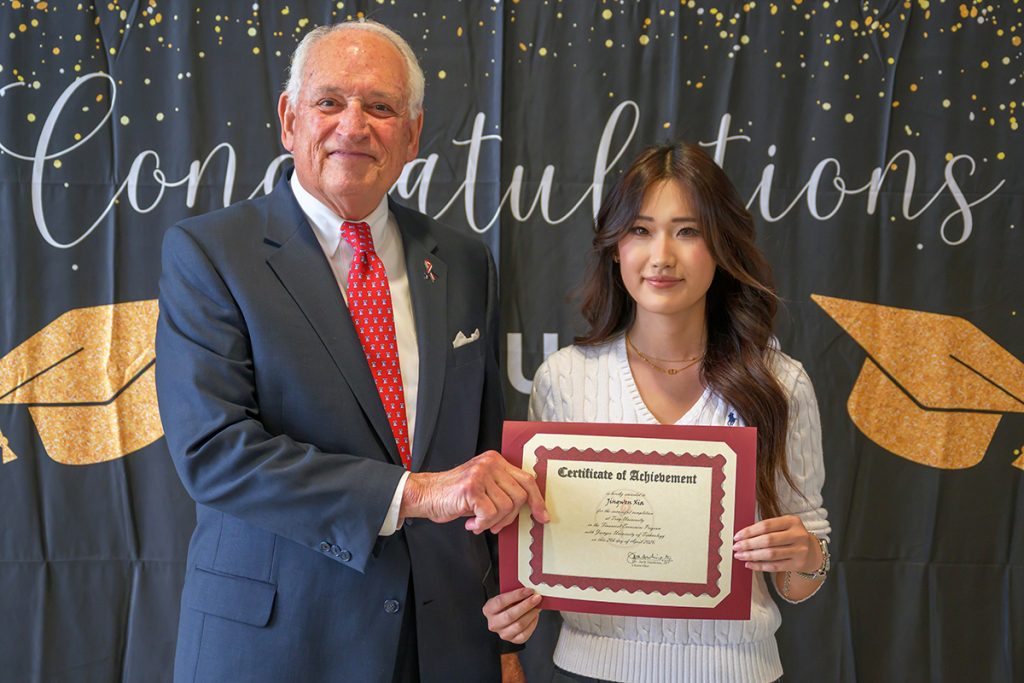 A photo of Chancellor Dr. Jack Hawkins Jr. with a graduating 1+2+1 student.