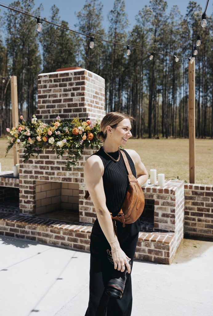 A photo of Katie with her camera equipment photographing a wedding