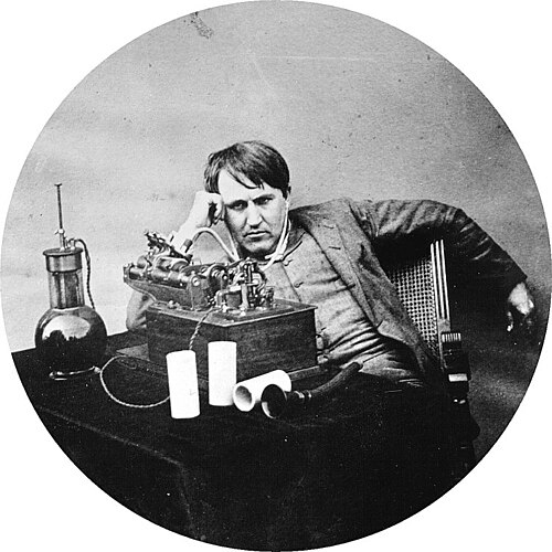 a picture of Thomas Edison in front of his invention