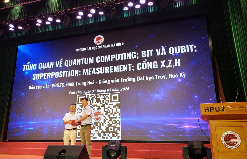 Dr. Dinh Trung Hoa on stage in Vietnam during the quantum computing conference in Vietnam.
