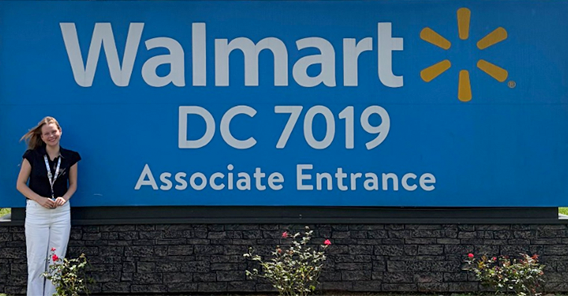 a girl standing in front a Walmart sign
