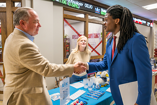 a man shaking hands with a student